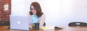 QA manager using QMSWrapper software on a laptop to streamline ISO compliance and quality management workflows for medical device manufacturing.