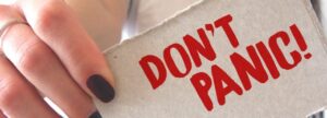 "DON'T PANIC!" sign in red text, symbolizing a calm approach to navigating ISO 13485:2016 and 2026 FDA QMSR regulatory deadlines.