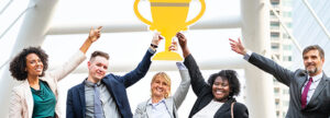 Five happy medical device company employees in professional attire holding a gold trophy together, celebrating a successful ISO 13485 audit and QMS certification.