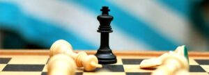 A black chess king standing victoriously over fallen white pieces on a chessboard, representing how integrated QMS chat and collaboration tools outperform traditional email in medical device team environments.
